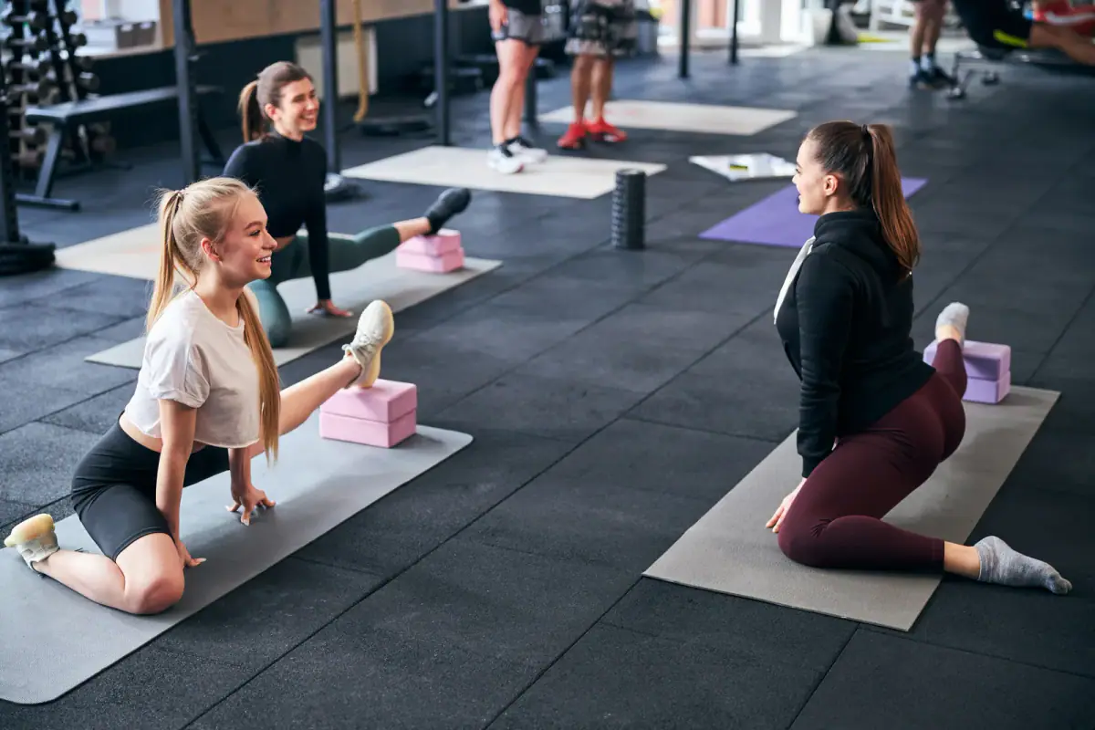 A group of fit women exercising and stretching, relevant to square feet per person for a small group class