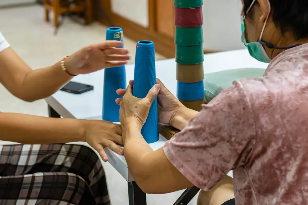 A stroke patient doing hand function training with a stacking cone, relevant to starting a private pay occupational therapy practice