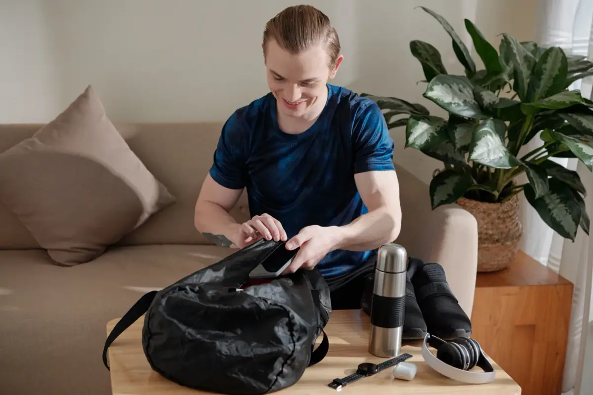 A man packing a gym bag, relevant to the startup budget for an independent personal trainer