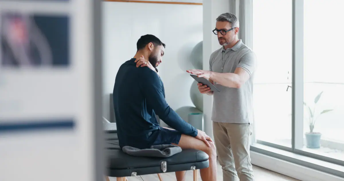 A clinic consultation about shoulder pain with a tablet, relevant to a superbill for cash pay physical therapy