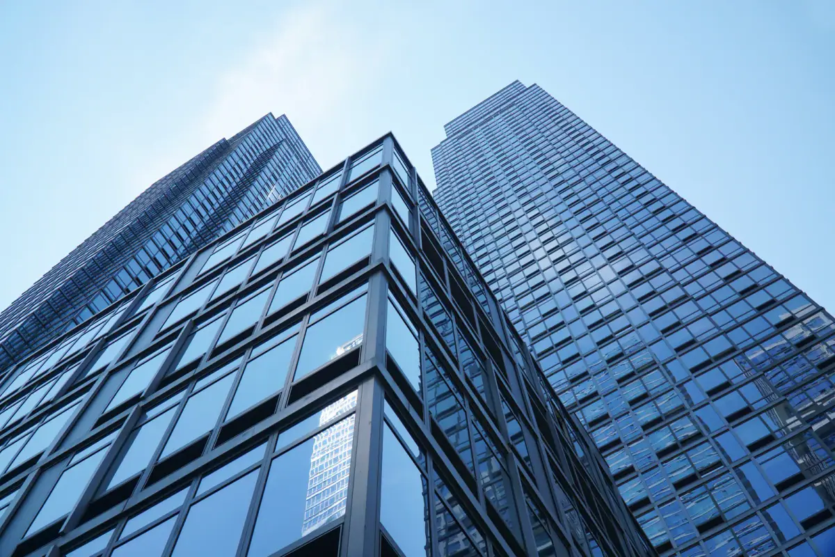 Low angle view of a modern office building with blue glass windows, the type of site for training clients in an office building gym