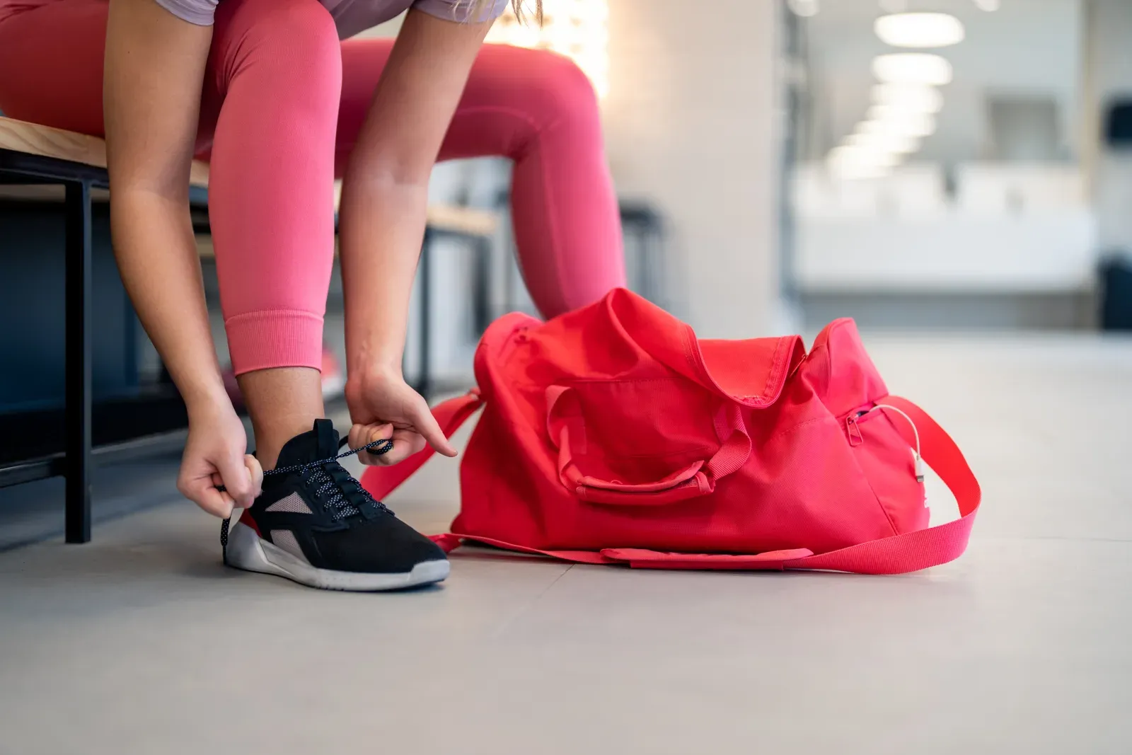 Lacing up sneakers on the gym floor before a training session