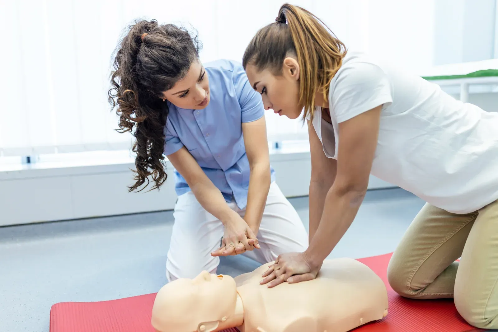 Practicing CPR on a training doll during a first aid certification class