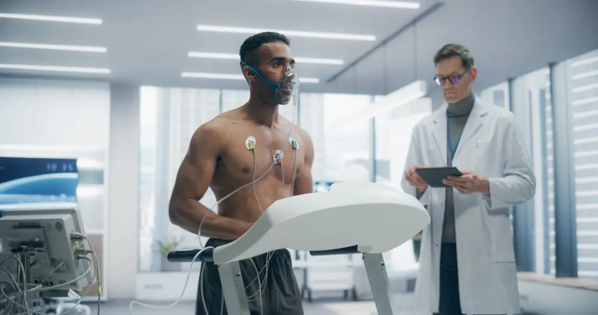 Athlete wearing an oxygen mask on a treadmill in a lab, with sensors, a setup for VO2 max testing for exercise physiologists