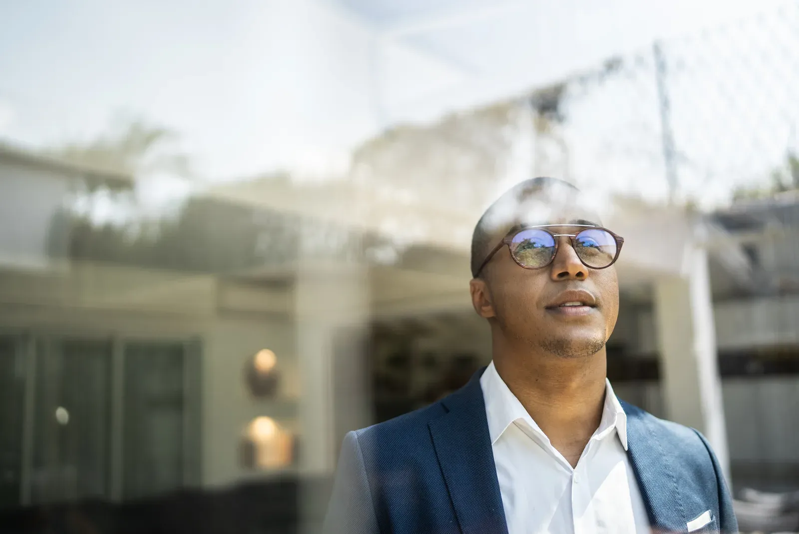 Businessman looking out a window, weighing his next career move