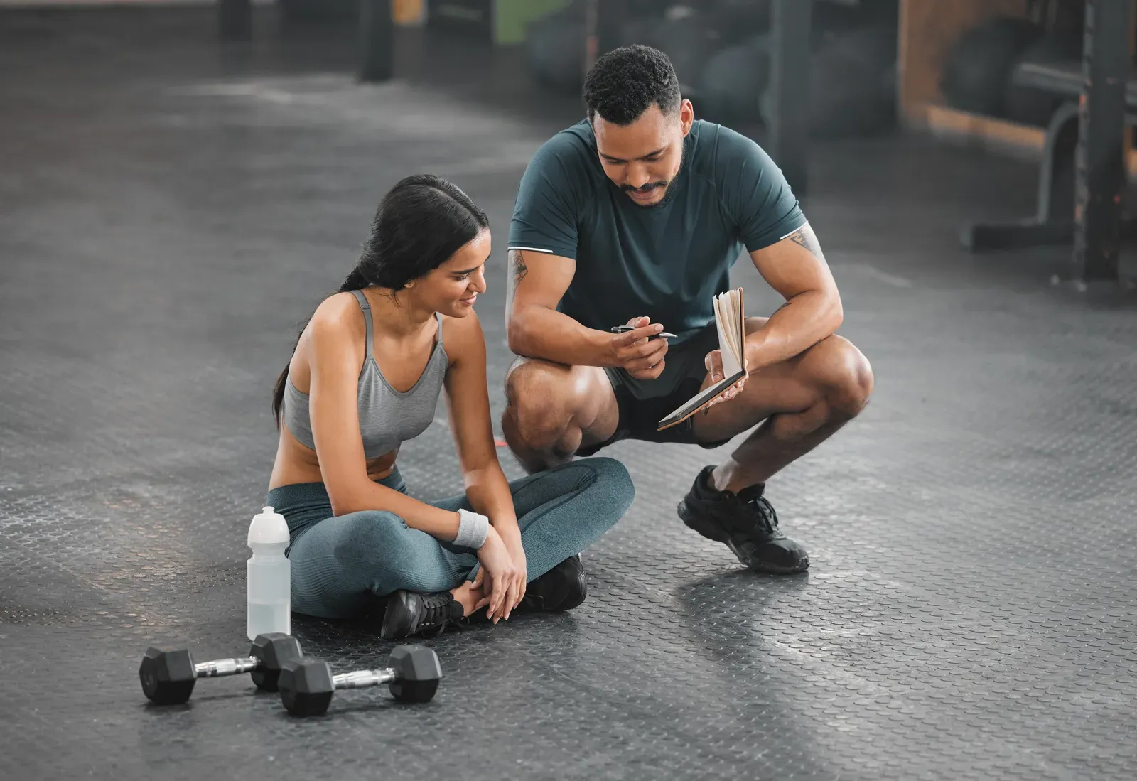 Coach explaining an exercise to a client in a training gym