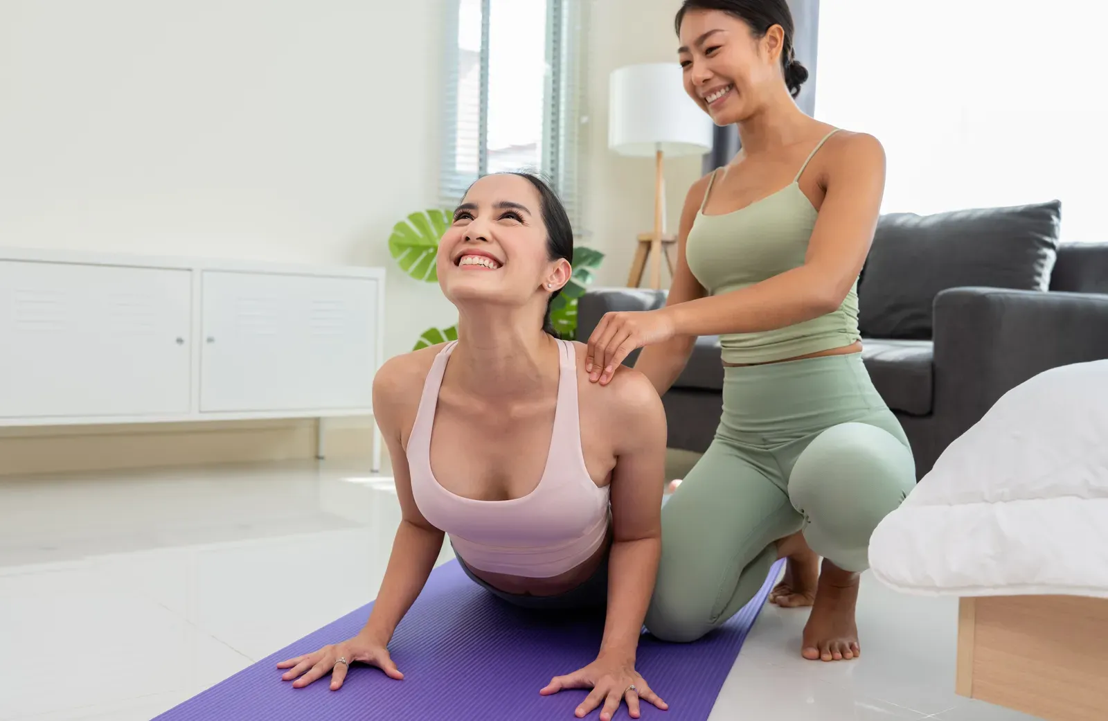 Yoga instructor working one on one with a student in a quiet room