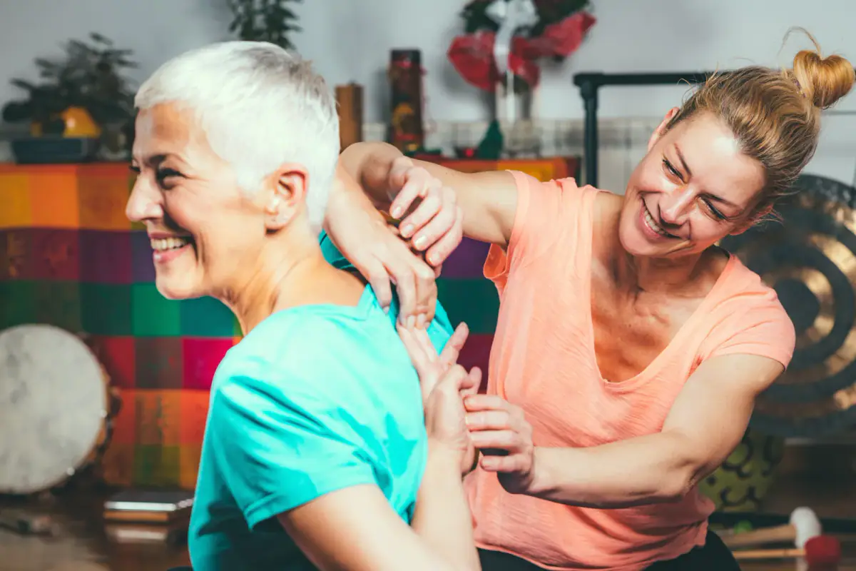 Yoga therapist guiding a client through a supported breathing practice in a calm room