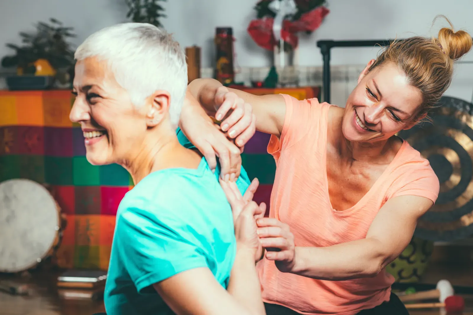 Yoga therapist guiding a client through a supported breathing practice in a calm room
